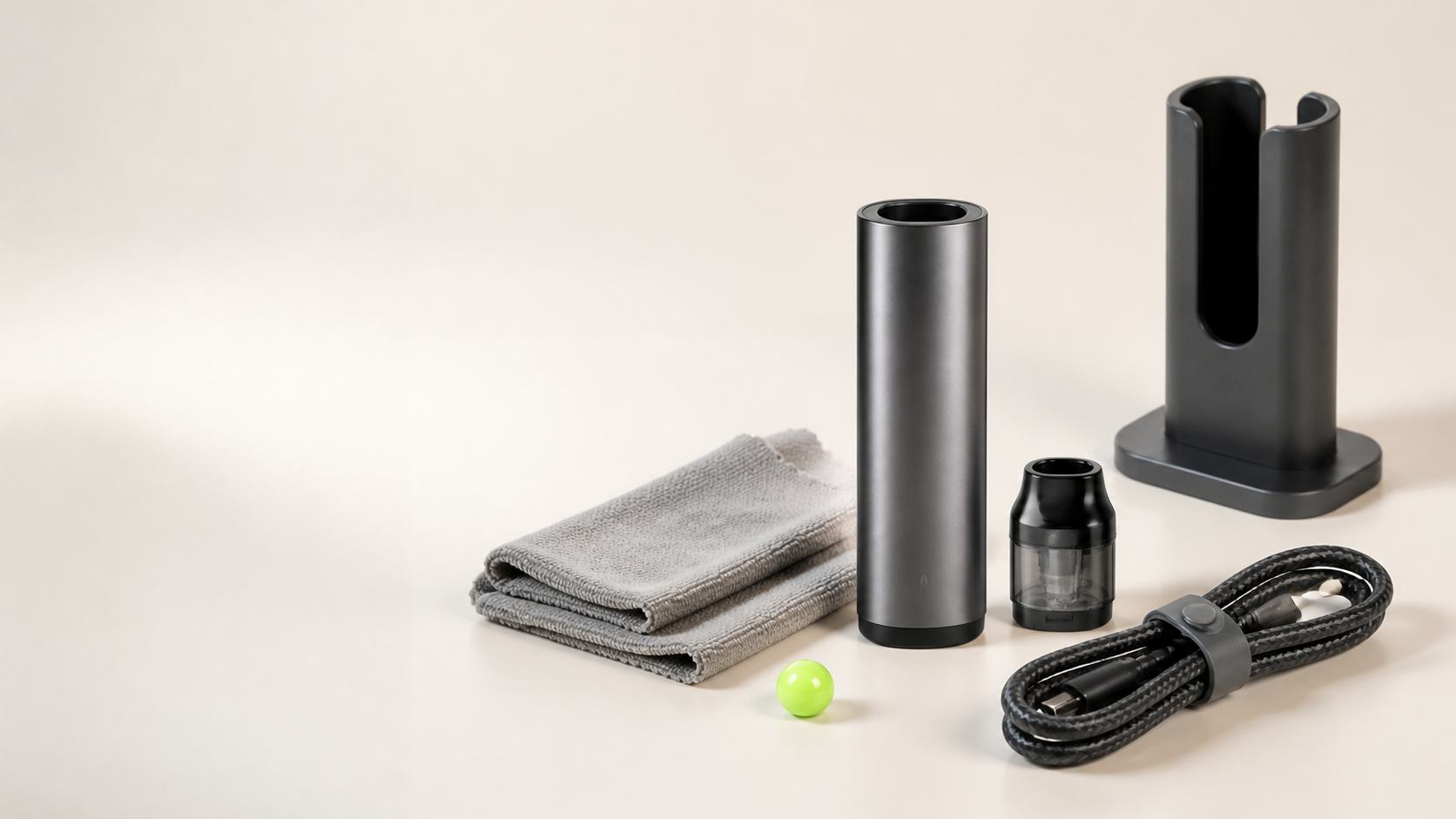 Abstract refillable device parts arranged with a folded cloth, charging cable, stand and lime-green sphere.